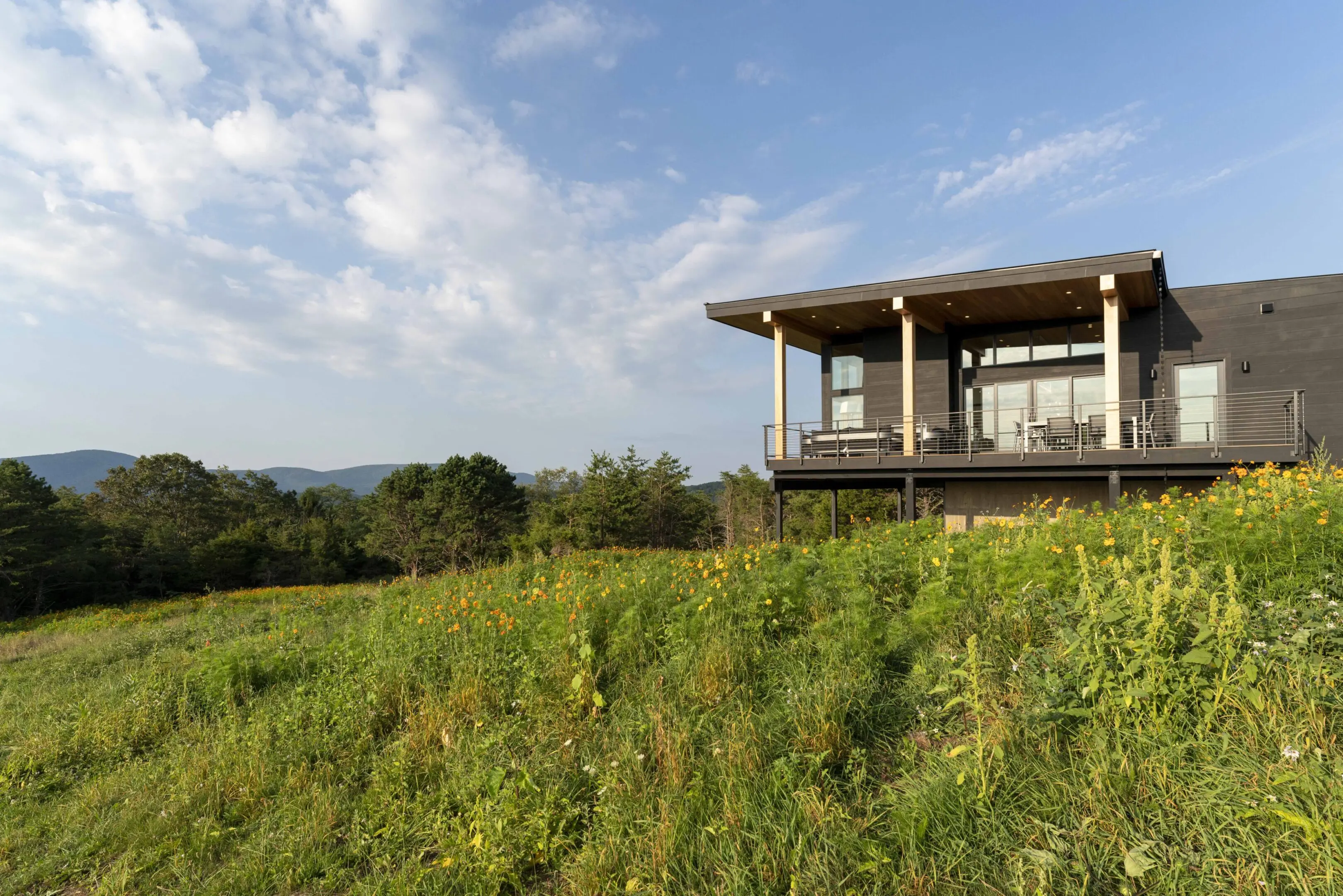 A house sitting on top of a hill with grass.