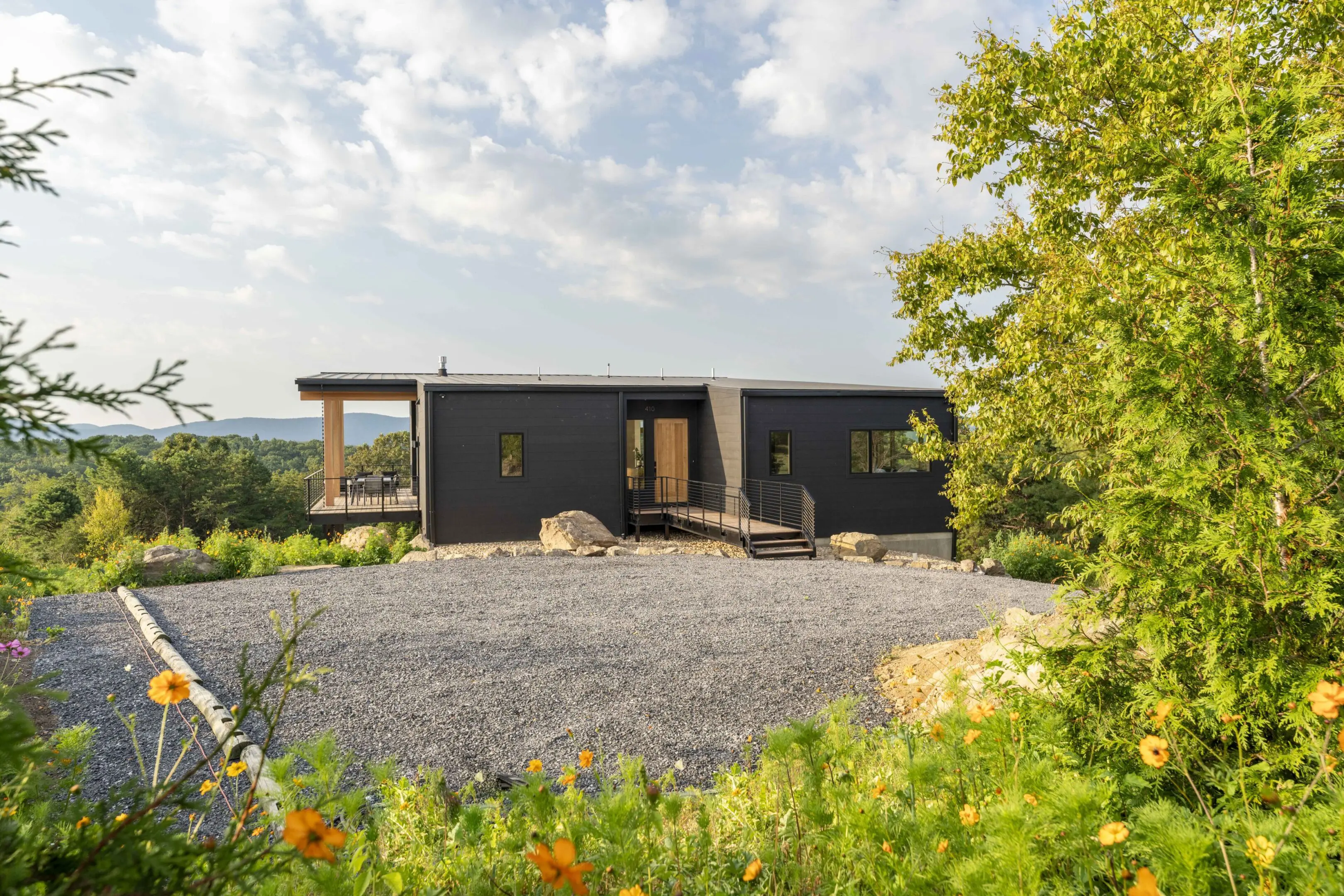 A black house with a lot of rocks in front