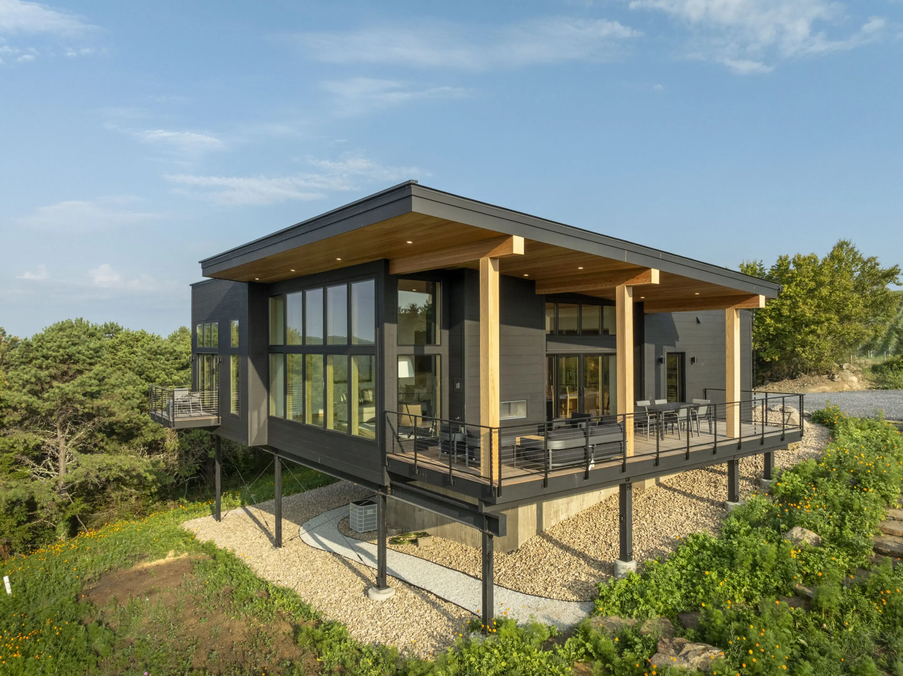 A modern house with a deck and patio on the side.