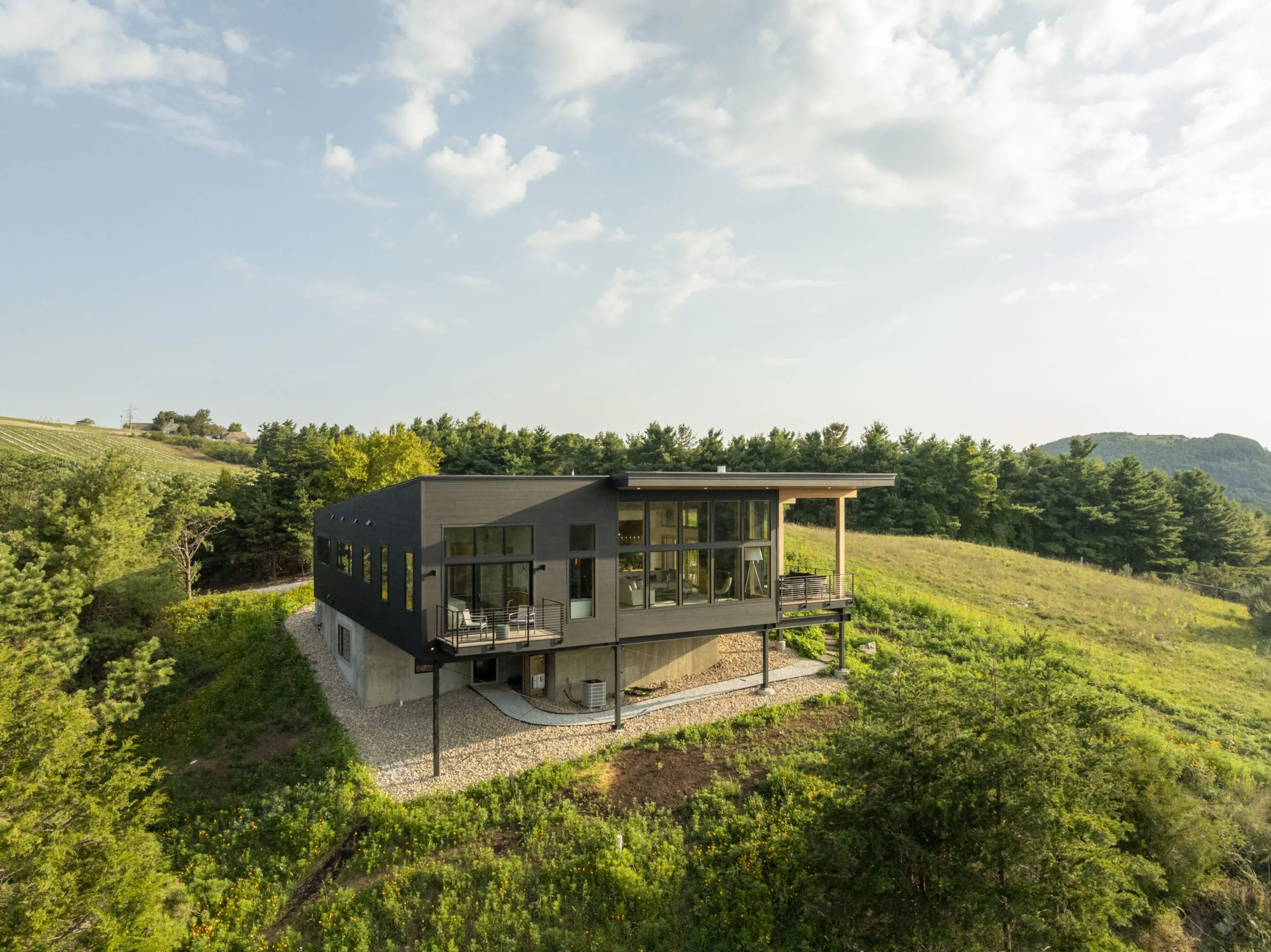A house sitting on top of a hill with trees in the background.