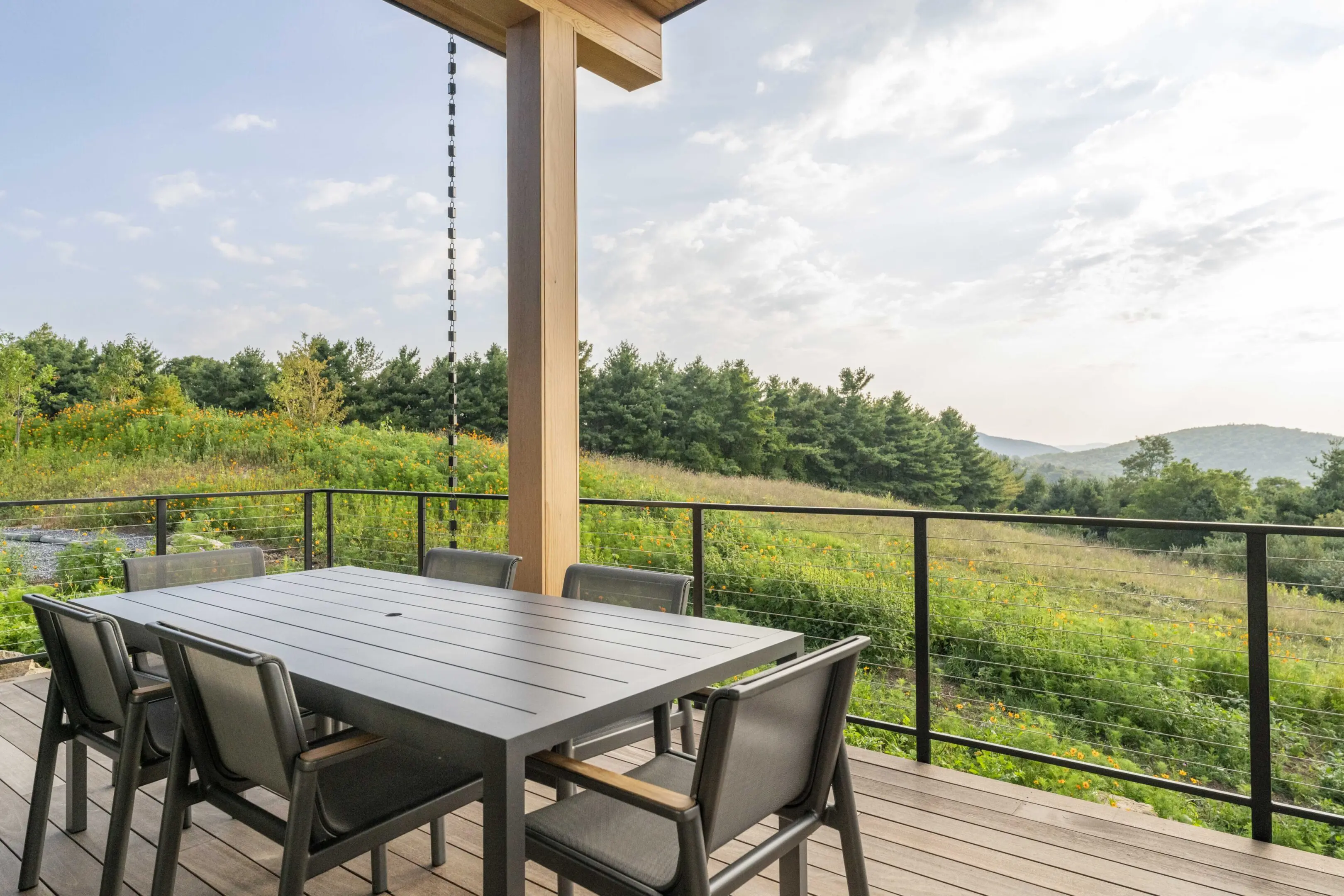 A table and chairs on the deck of a house.