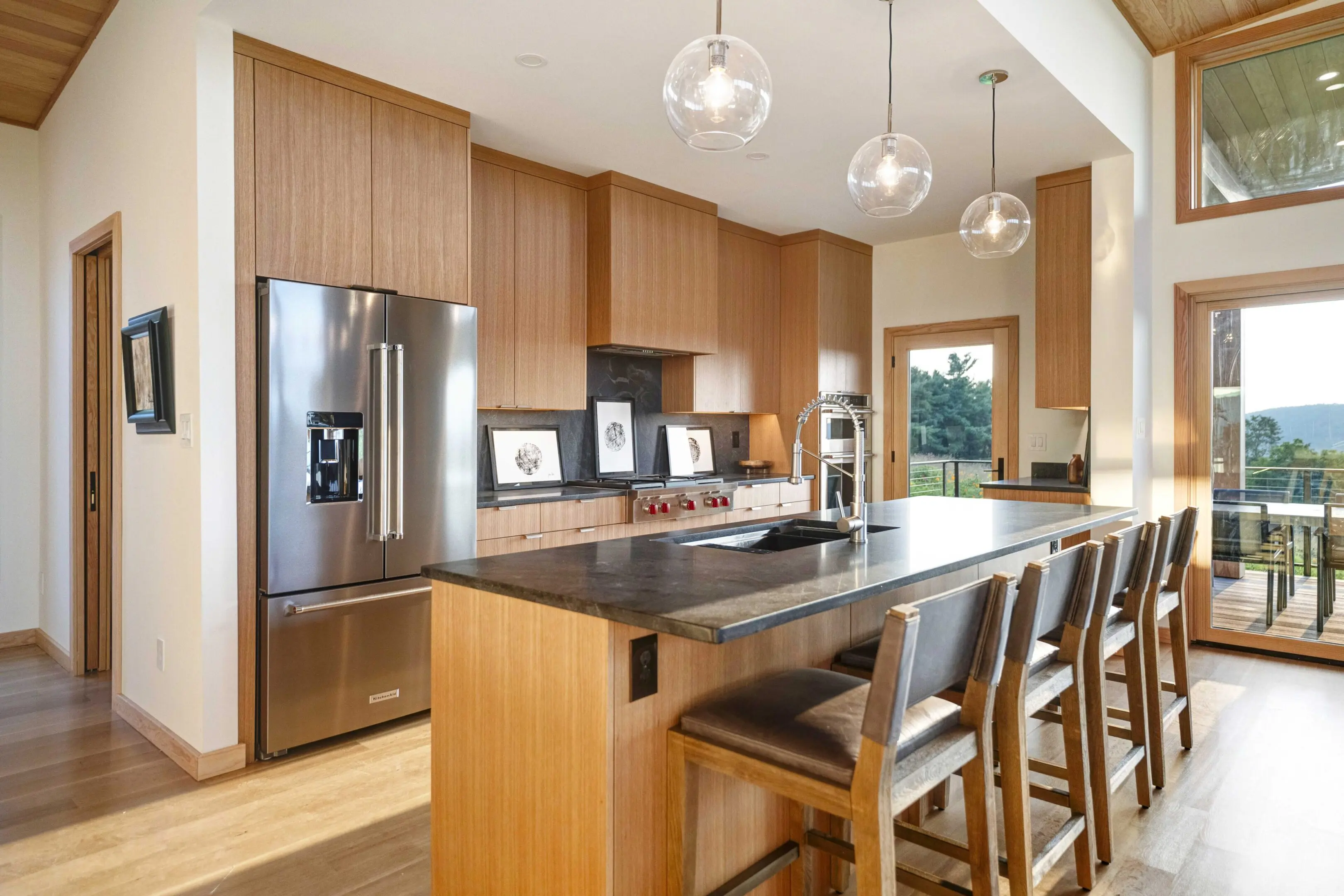 A kitchen with wooden cabinets and black counter tops.