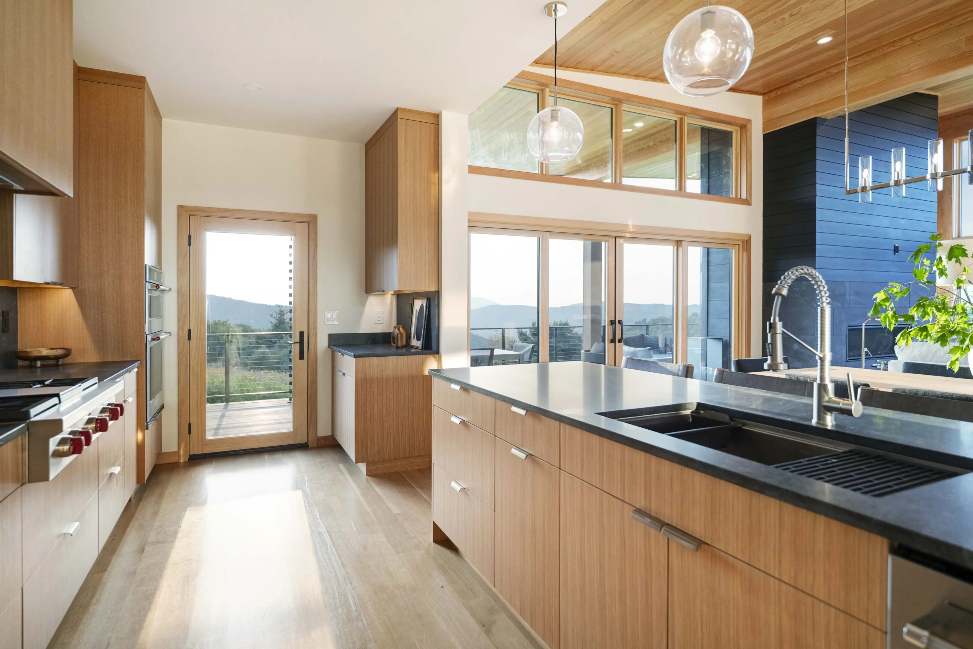 A kitchen with wooden cabinets and black counter tops.