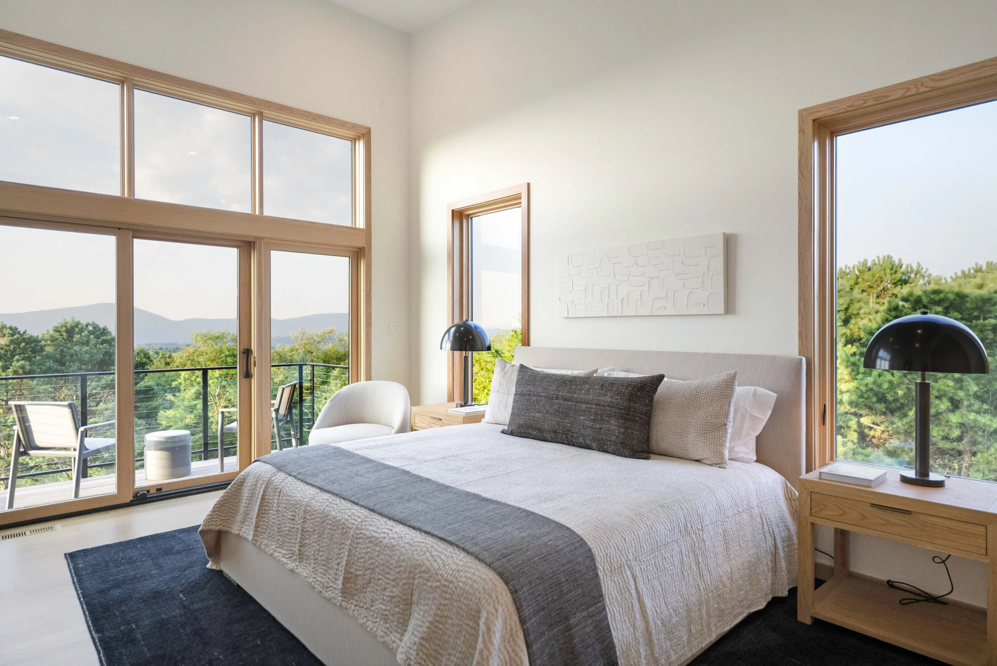 A bedroom with a large bed and two windows.