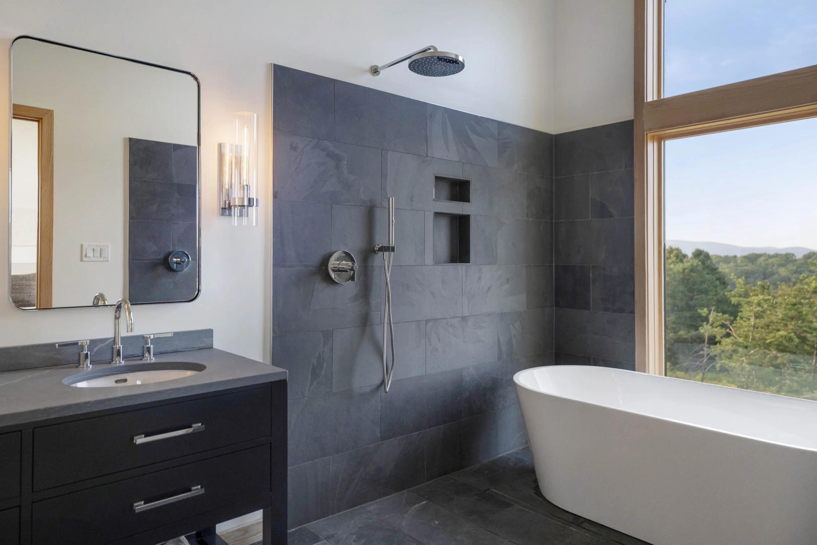 A bathroom with a tub, sink and mirror.