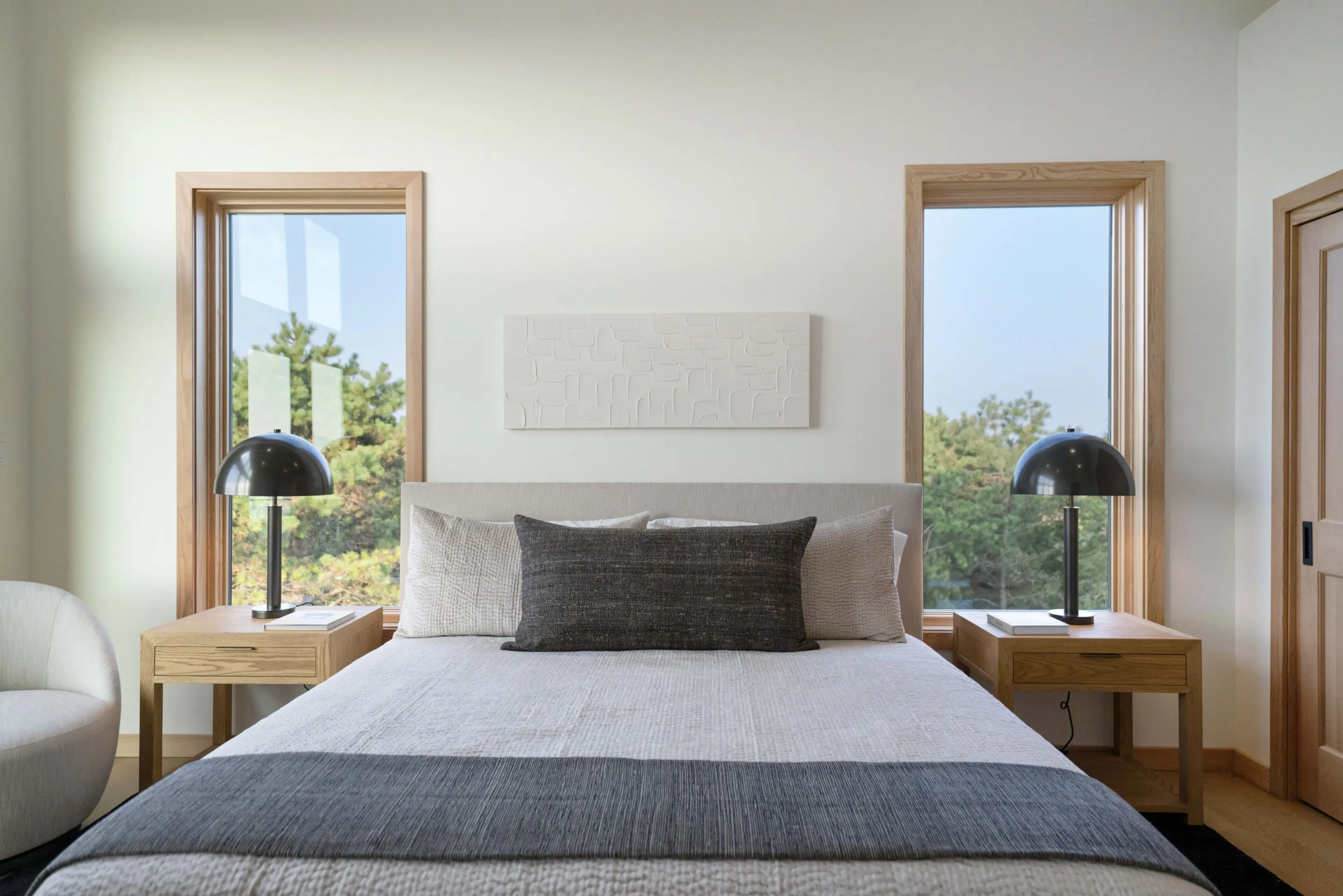 A bed room with two lamps and a window