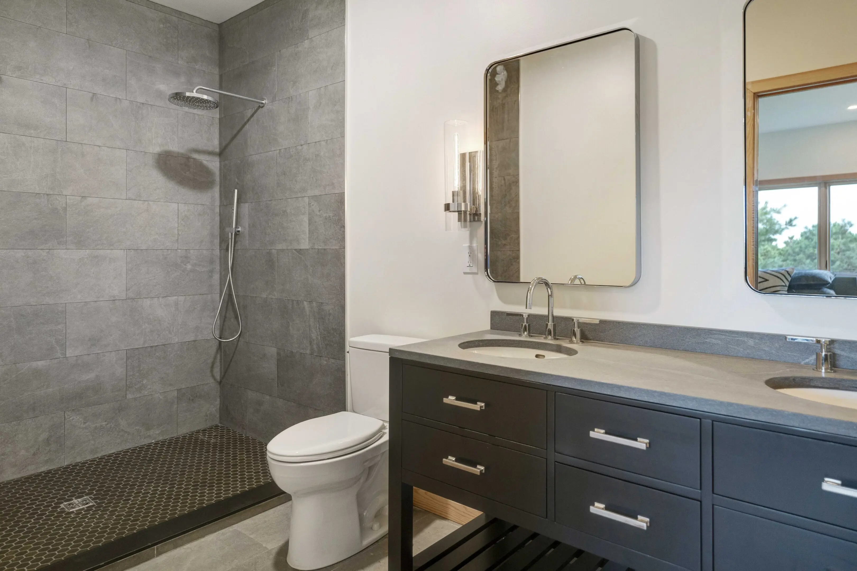 A bathroom with a toilet, sink and shower.