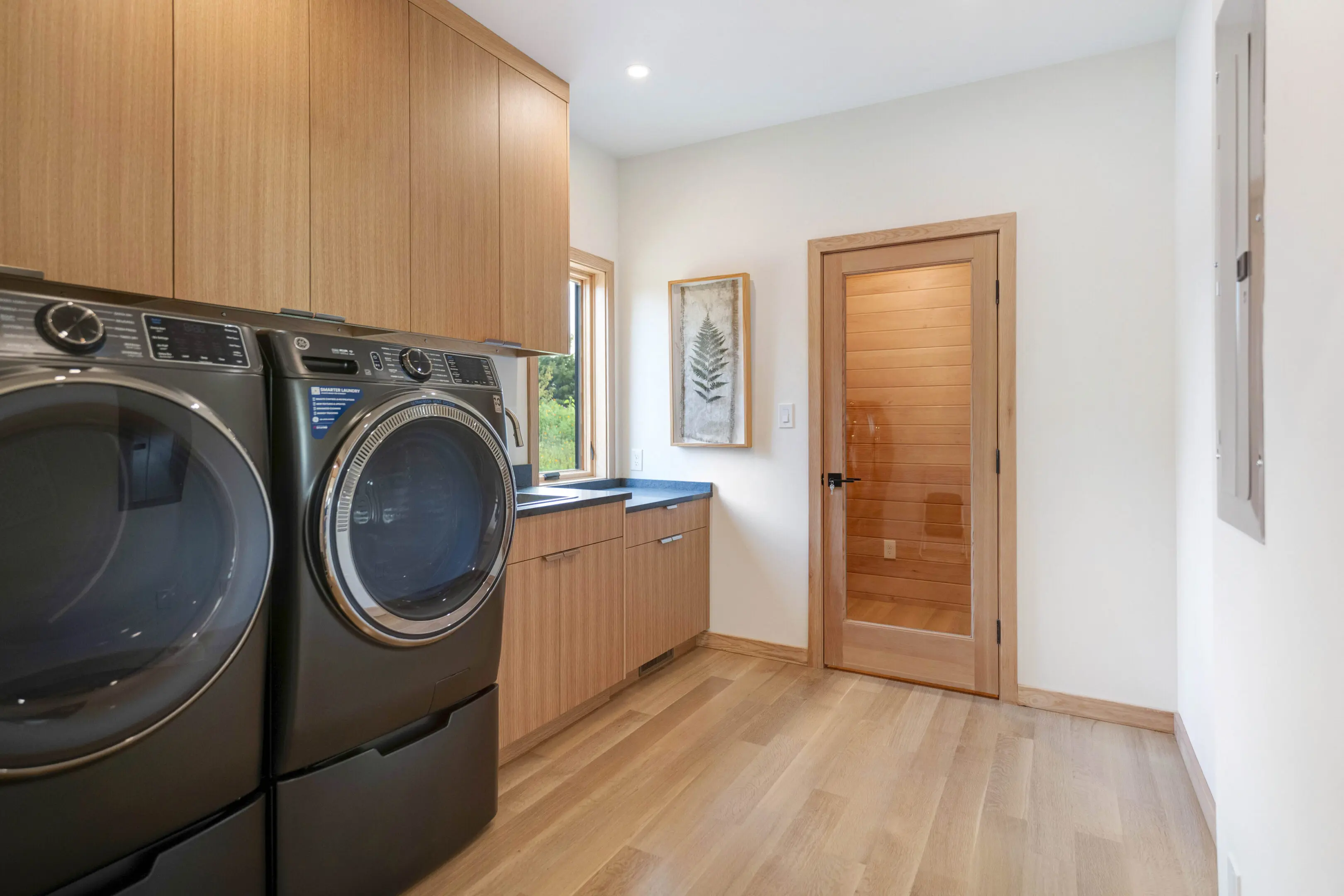 A room with two wooden cabinets and a washer.