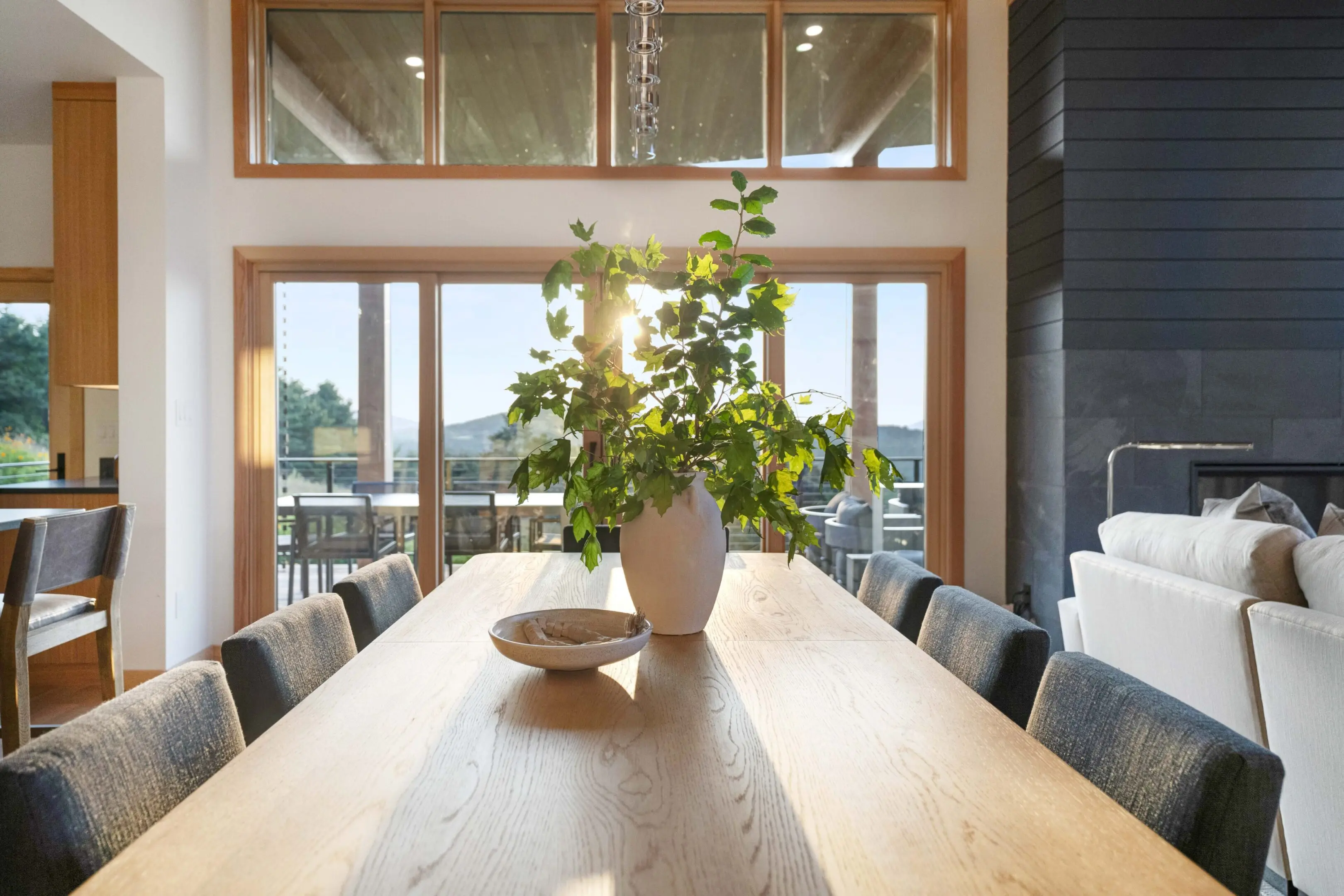 A large wooden table with a plant in the middle of it.