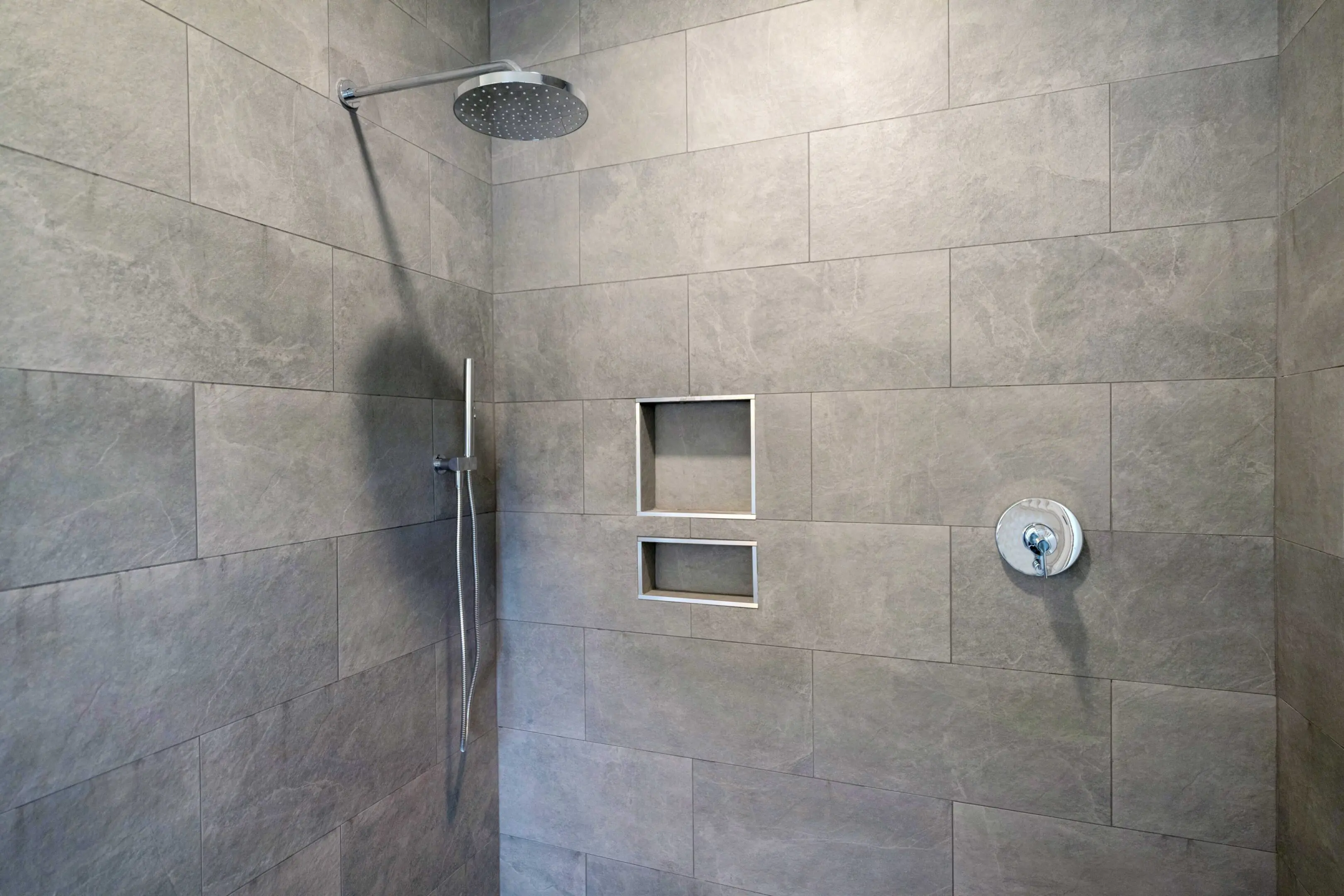 A bathroom with a shower and tiled walls.
