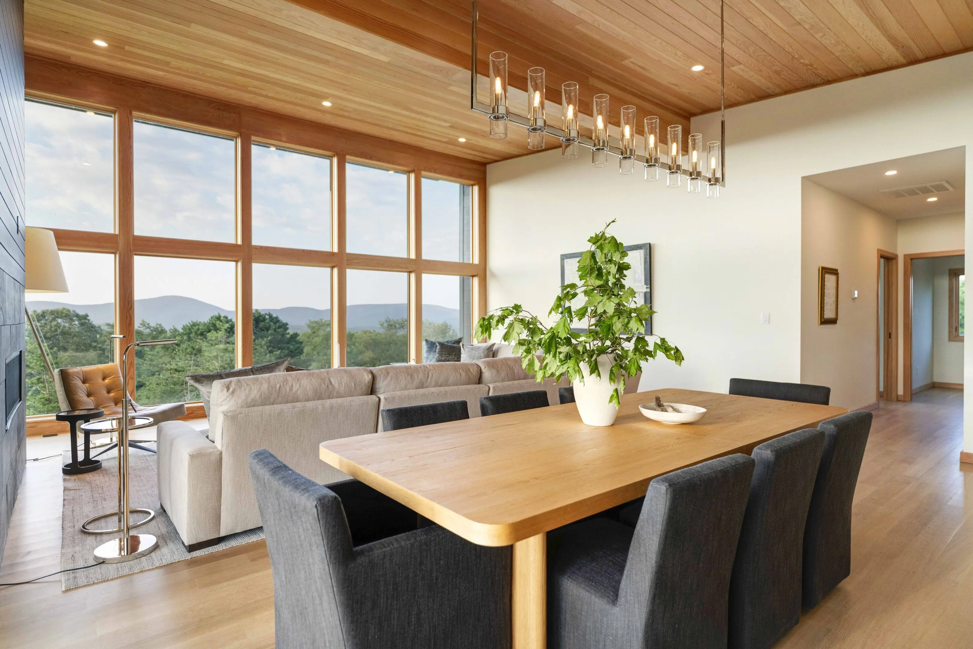 A dining room table with chairs and a couch in the background.