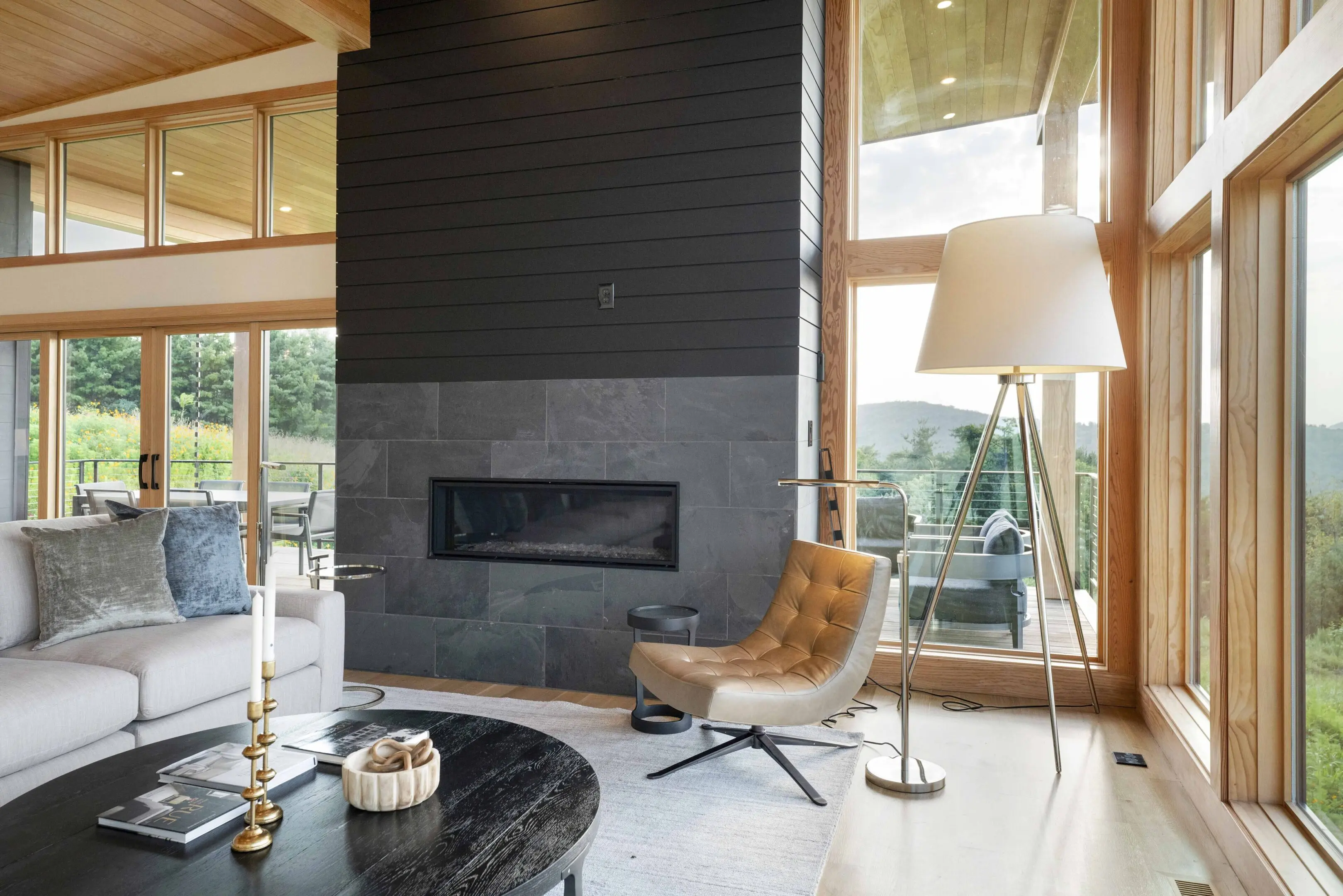 A living room with a fireplace and large windows.