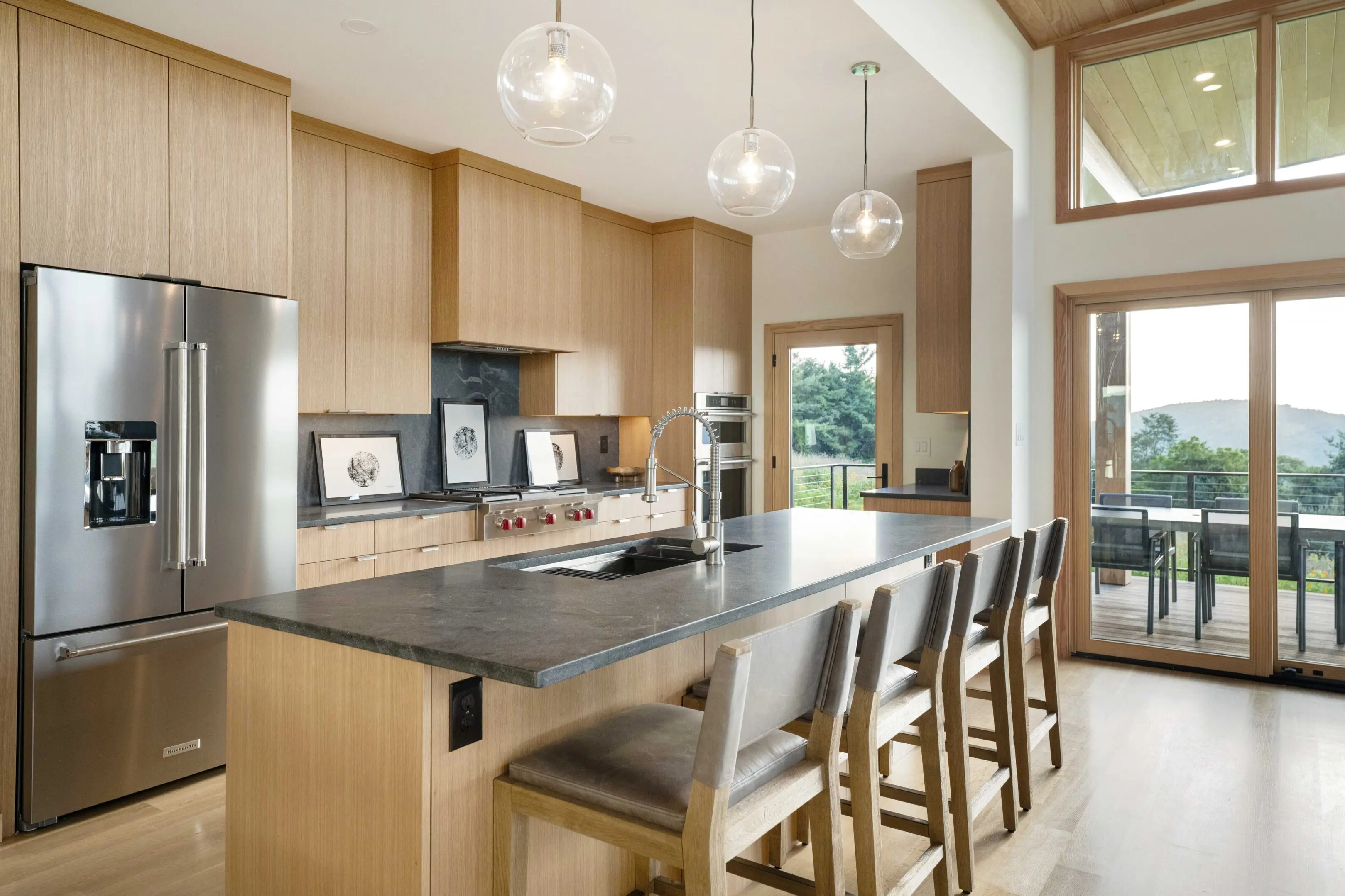 A kitchen with wooden cabinets and black counter tops.