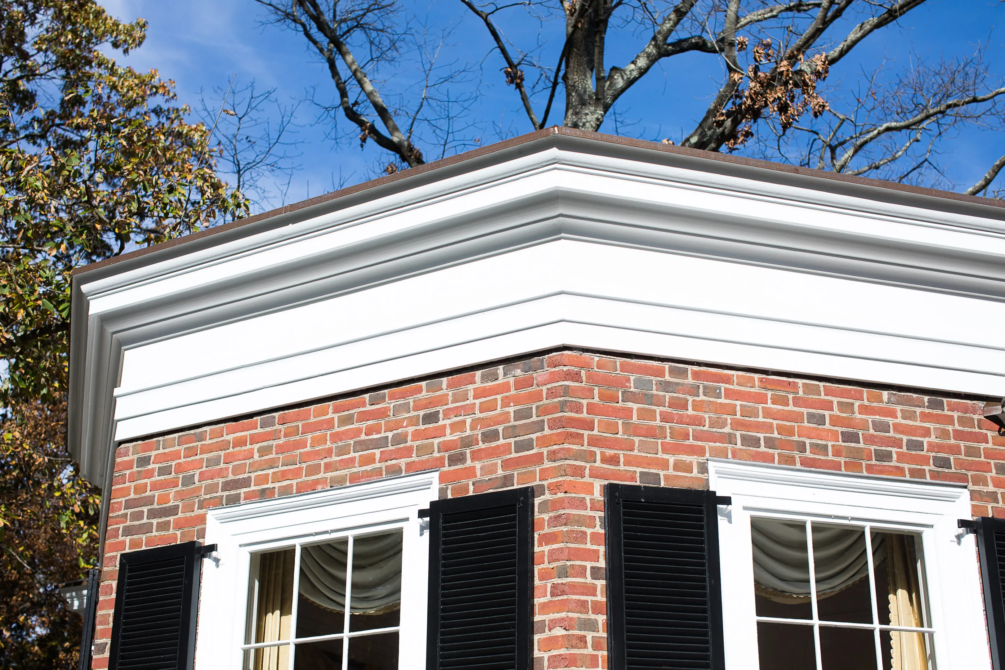 A brick building with a white trim and windows.