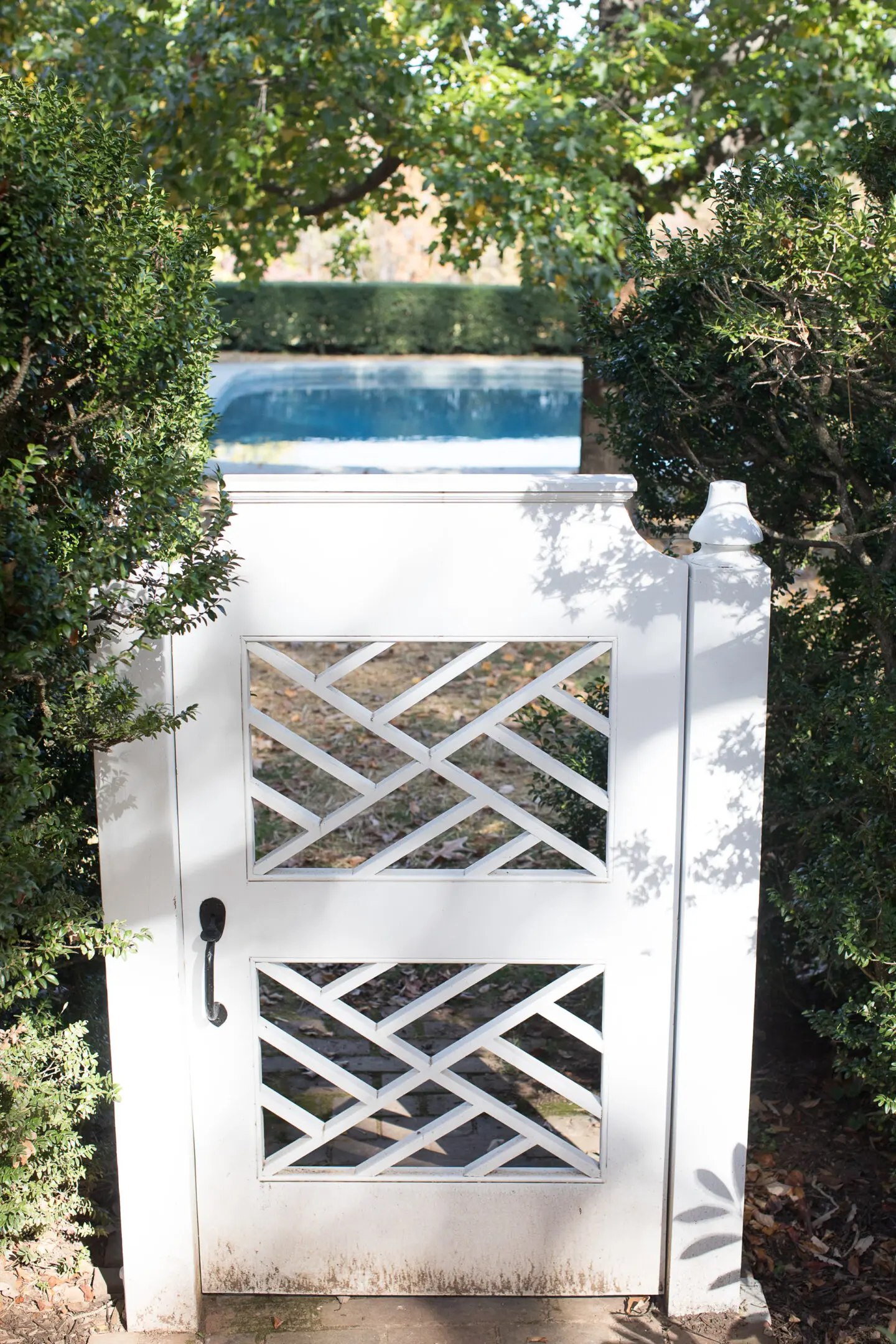 A white gate with a lattice design on the side.