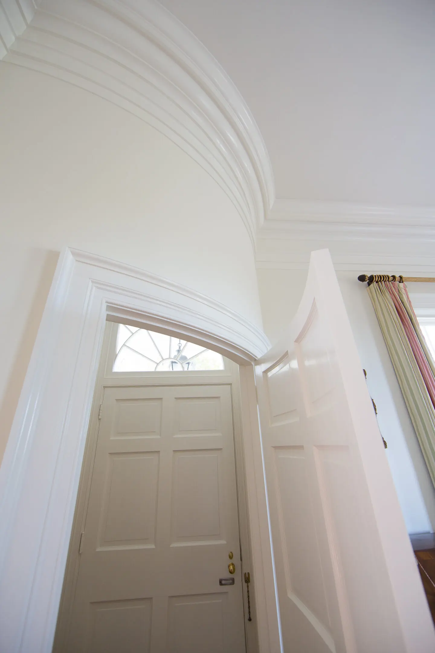 A door and window in the hallway of a house.