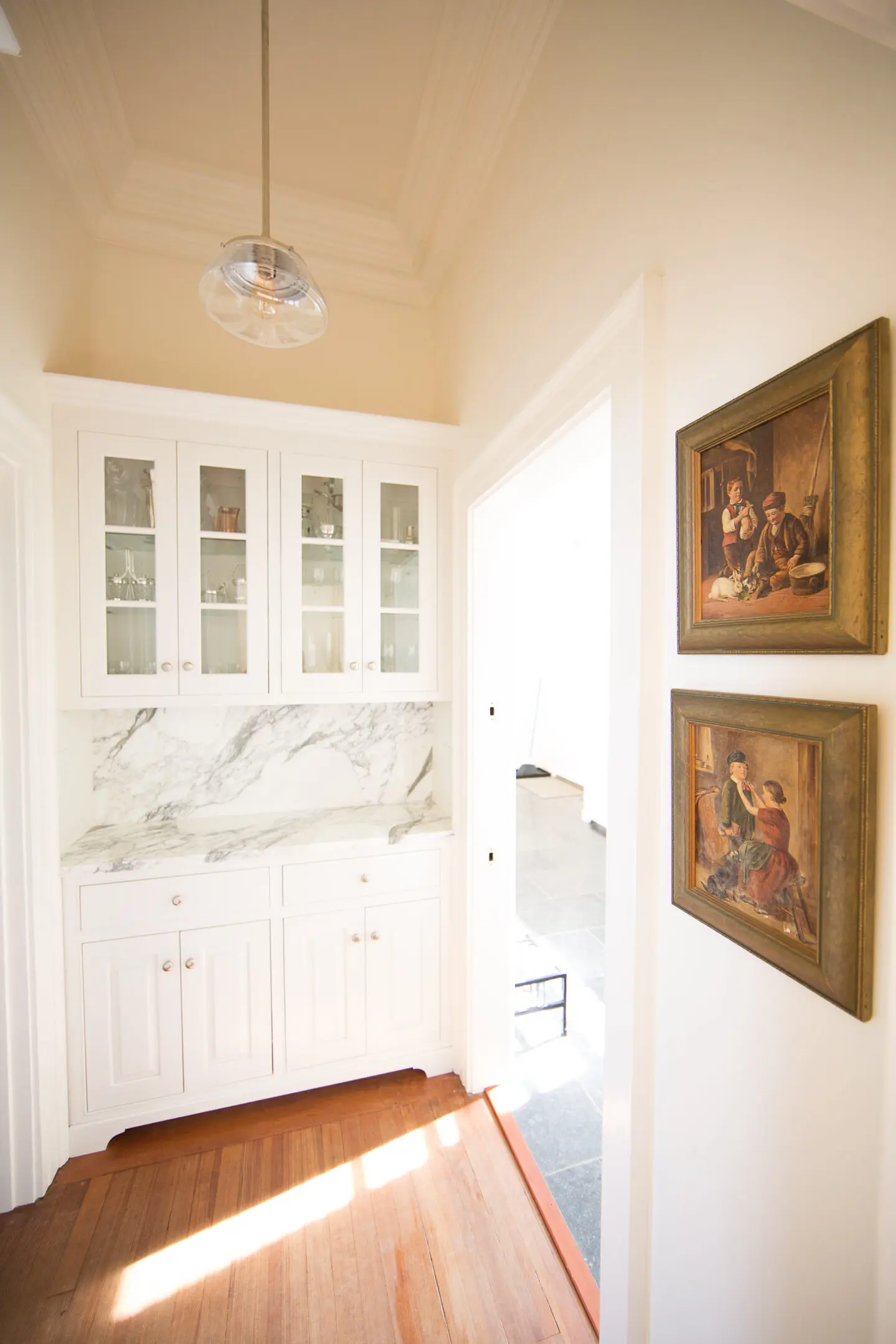 A hallway with two paintings on the wall.