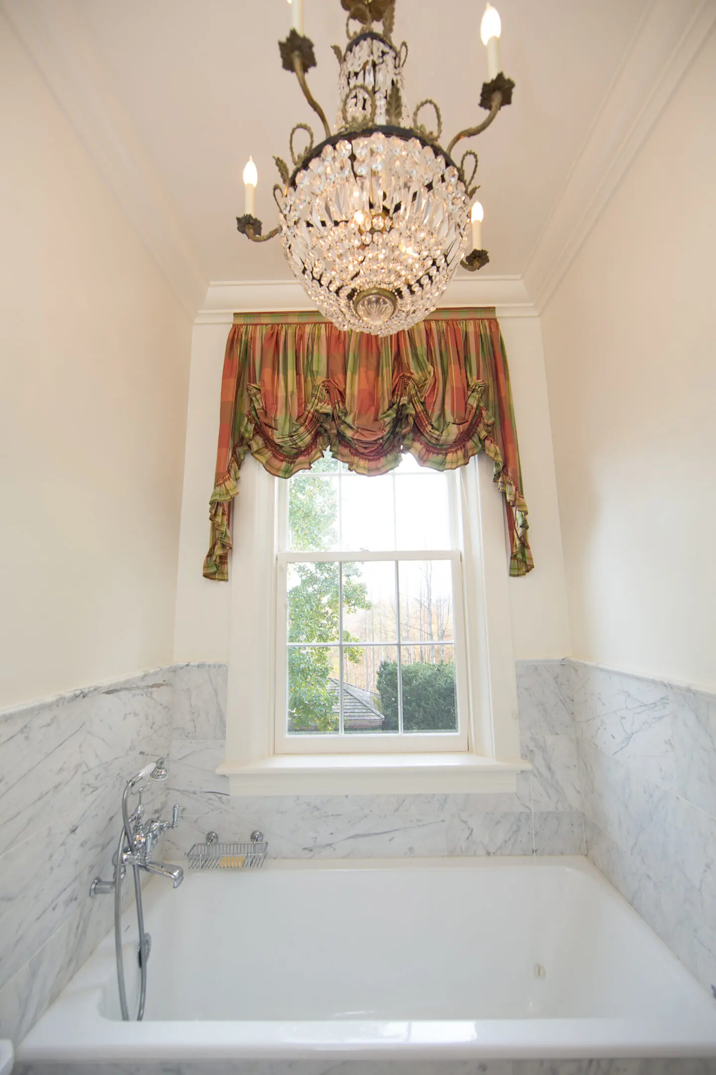 A bathroom with marble walls and a window.
