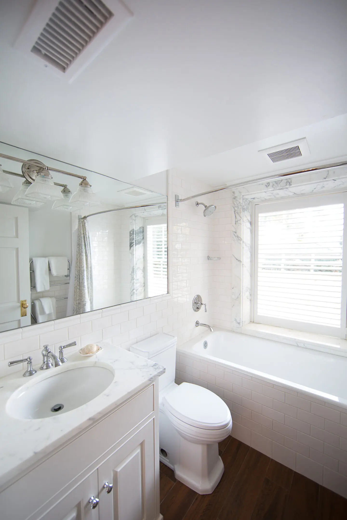 A bathroom with white fixtures and a large mirror.