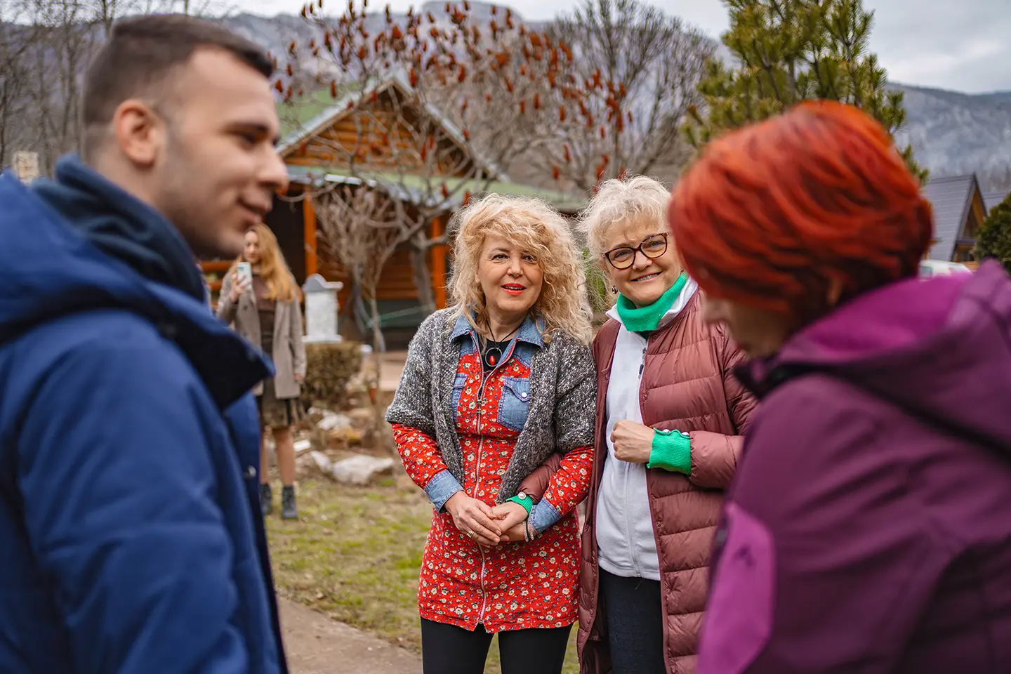 A group of people standing around talking to each other.